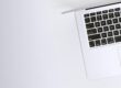 Free Aerial view of a sleek laptop keyboard on a clean, white surface, ideal for tech backgrounds. Stock Photo