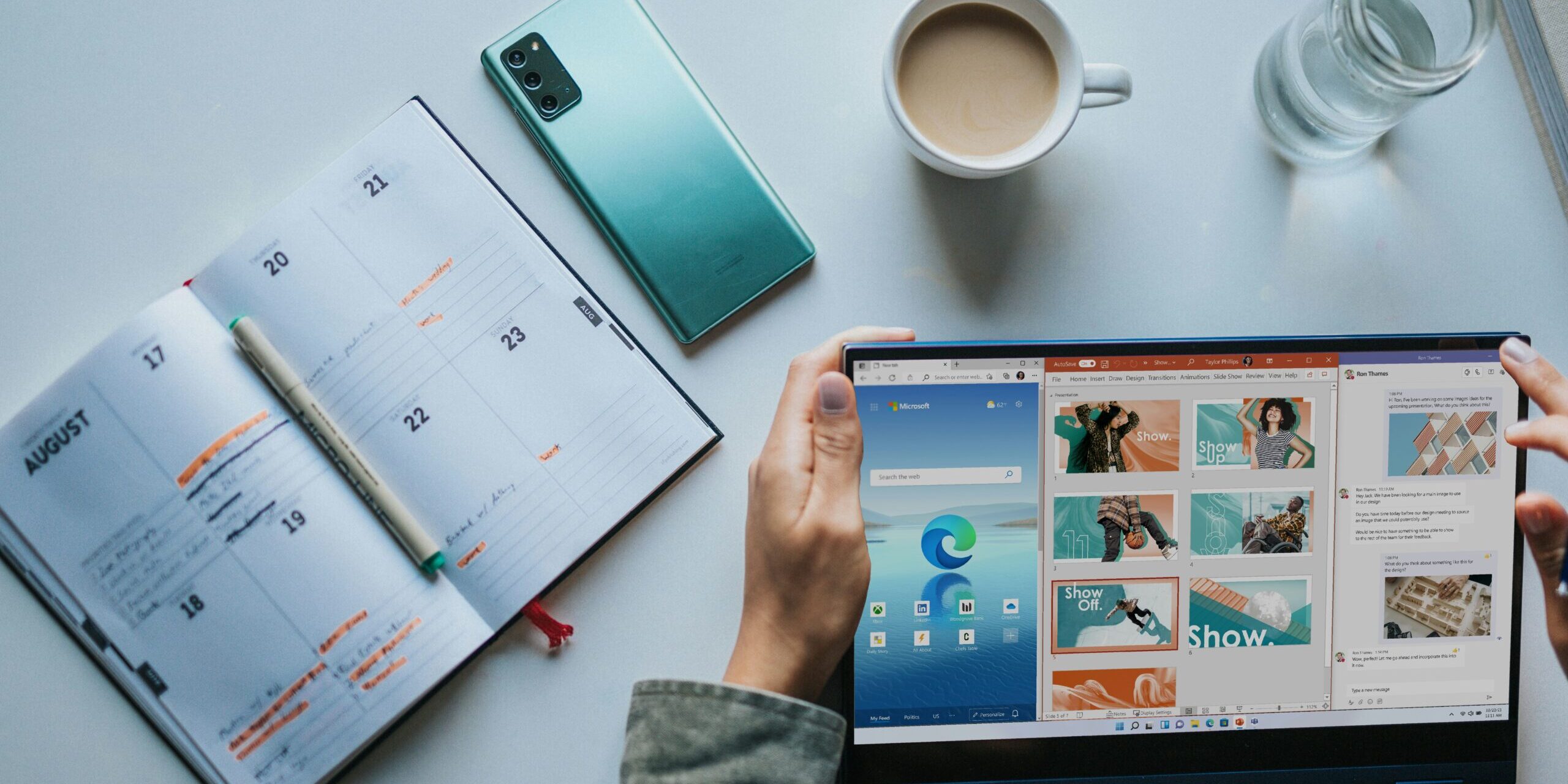 person using Windows 11 computer beside white ceramic mug on white table