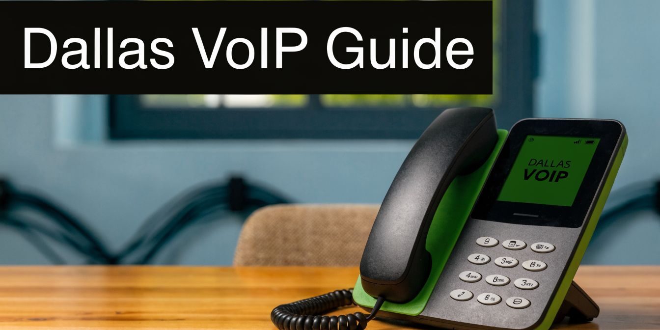 Desk phone on a wooden table with a large black banner reading 'Dallas VoIP Guide'.