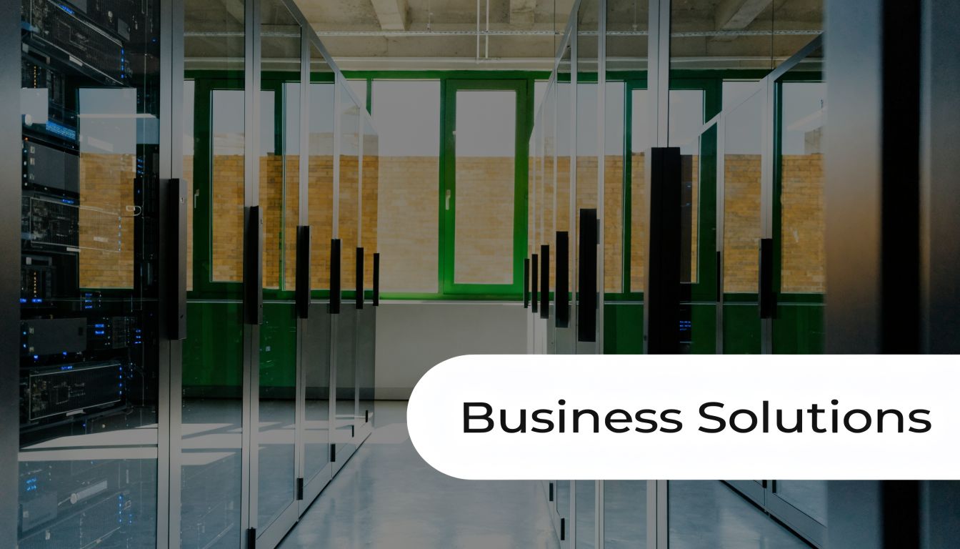 Rows of server racks in a modern data center facility viewed through glass panels.