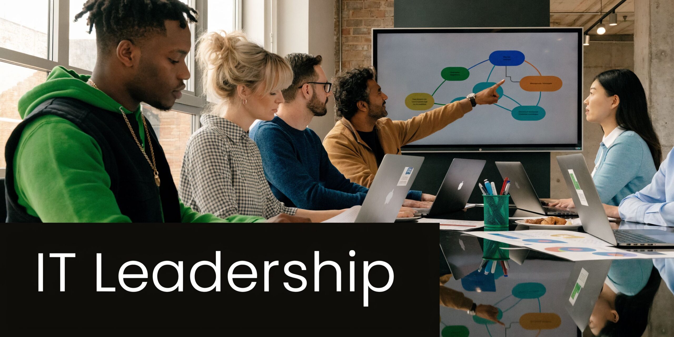 A diverse team of professionals collaborating during an IT leadership meeting in a modern office boardroom.