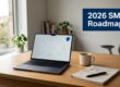 Desk workspace with an open laptop displaying a cloud network diagram, a cup of coffee, a notebook and pen, plants by the window, and a blue '2026 SMB Roadmap' banner to the right.