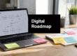 Laptop on a wooden desk showing a 'Project Roadmap' diagram with sticky notes nearby