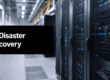 Data center with server racks and a black banner reading 'IT Disaster Recovery'