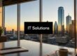 Office conference room with a city skyline at sunset; a black screen displays 'IT Solutions' in white text.
