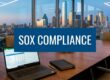 Conference room with laptop open to a spreadsheet, a notebook on the table, and a city skyline; banner reads 'SOX COMPLIANCE'.