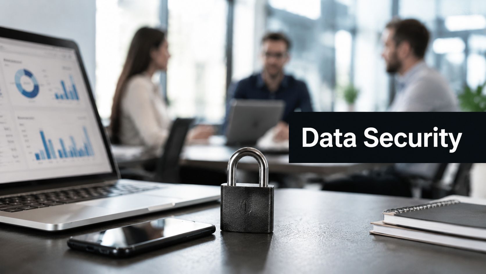 Lock on a desk with a laptop and office collaborators in the background; banner reads Data Security, emphasizing cybersecurity focus.
