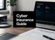 Black sign reading 'Cyber Insurance Guide' on a desk beside a laptop with a security dashboard visible on screen