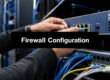 IT technician configures a firewall appliance in a data center, adjusting cables and ports on a rack.
