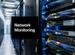 Data center with server racks and blue network cables; a black sign reads 'Network Monitoring'.