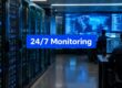 Data center with server racks and blue glow, and a prominent '24/7 Monitoring' banner across the image.