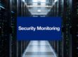 Server racks in a data center with a blue banner reading 'Security Monitoring' in the center